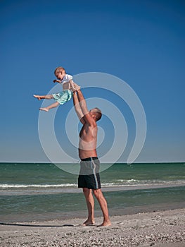 Dad and Baby playing on seaside in summertime. Happy family and happy childhood concept. Little boy having fun with