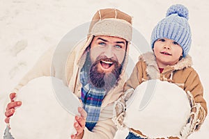 Dad and baby son playing together outdoors. Winter father and son. Happy child playing with snowball against white