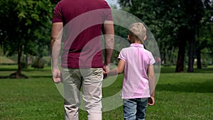 Dad and boy holding hands, walking away, parenting and friendship, happy family