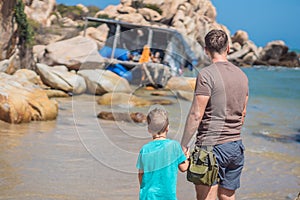 Dad care about Son near sea, walk spend time together explore new. Man hold kid hand, look far away. Nature sea rock