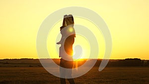 Dad carries on shoulders of his beloved child, in rays of sun. Father walks with his daughter on his shoulders in rays