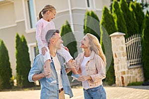 Dad carrying a girl on his shouldres during family walk