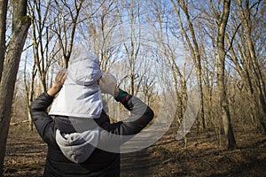 Dad carrying his baby on his shoulders in forest