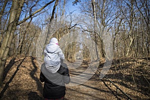 Dad carrying his baby on his shoulders in forest