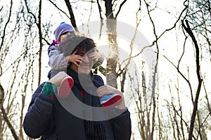 Dad carrying his baby on his shoulders in forest