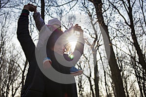 Dad carrying his baby on his shoulders in forest