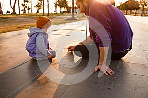 Dad and child draw with chalk on the pavement.