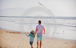 Dad and child enjoying outdoor. Father and son walking on sea.