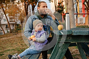 Dad and child have a picnic in the city park.