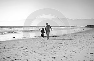 Dad and child holding hands and walk together. Father and son walking on sea. Family travel, vacation, father's day