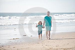 Dad and child holding hands and walk together. Father and son walking on sea. Lifestyle and family vacation, happiness