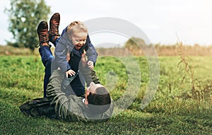 Dad, child and playing together in nature with happy laugh, grass and bonding in outdoor garden. Father, son and playful