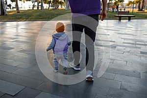 Dad and child are walking in the autumn park.