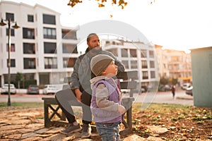 Dad and child are walking in the autumn park.