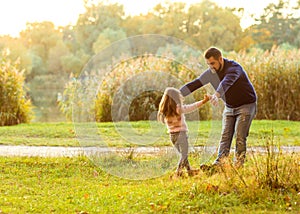 Dad and daughter in the autumn park play laughing