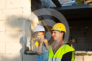 Dad and daughter are at construction site of their future home. The choice of the future profession of a builder is inherited by