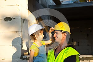 Dad and daughter are at construction site of their future home. The choice of the future profession of a builder is inherited by