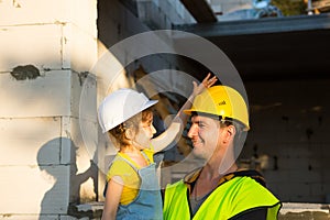 Dad and daughter are at construction site of their future home. The choice of the future profession of a builder is inherited by