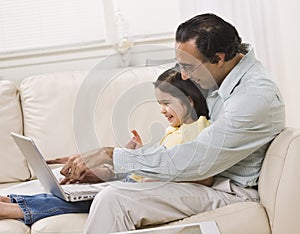 Dad and Daughter Look at Laptop