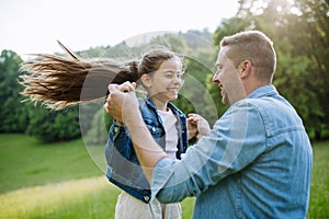 Dad with daughter, playing at meadow, running, having fun. Concept of fathers's Day and fatherly love.