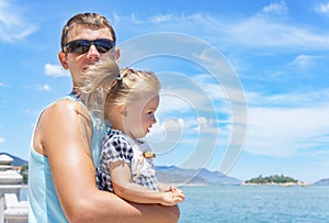 Dad and daughter playing on the promenade by the sea. young man, little girl