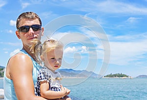 Dad and daughter playing on the promenade by the sea. young man, little girl