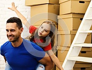 Dad and daughter pretend to fly by pile of boxes