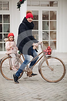 Dad and daughter in red hats riding a bike.