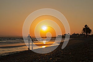 Dad and daughter silhouette go along sea, sun set on vacation day. Parent and kid, Father`s day, Family with small child,