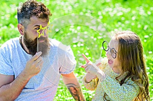 Dad and daughter sits on grass at grassplot, green background. Child and father posing with eyeglases photo booth