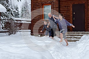 Dad, daughter and son are barefoot running in the snow. Winter day. Hardening is winter fun