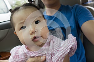 Dad and daughter taking pictures on car.