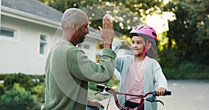Dad, daughter and teaching with bicycle, high five and happy with safety, support and celebration for goal. Father, girl