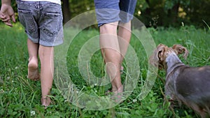 dad and daughter walk on the grass in park. happy family kid dream concept. father and daughter walk barefoot on the