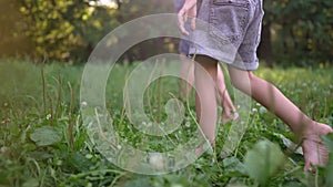 dad and daughter walk on the grass in park. happy family kid dream concept. father and daughter walk barefoot on the