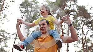 Dad daughter walk park. father carries daughter around his neck in a forest park. happy family kid concept. father play