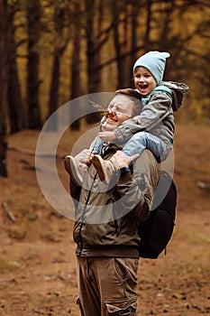 Dad and daughter walking in the autumn forest