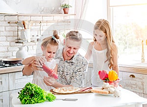 Dad with daughters preparing pizza