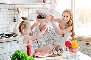 Dad with daughters preparing pizza