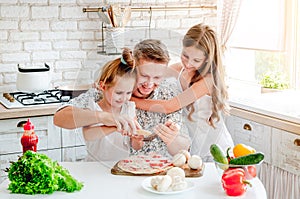 Dad with daughters preparing pizza