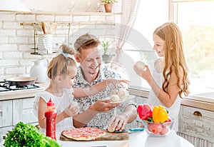Dad with daughters preparing pizza