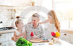 Dad with daughters preparing pizza
