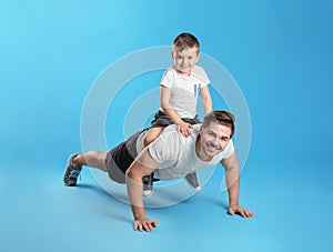 Dad doing push-ups with son on his back