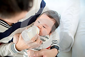 Dad feeding her baby daughter infant from bottle Adorable baby with a milk bottle.