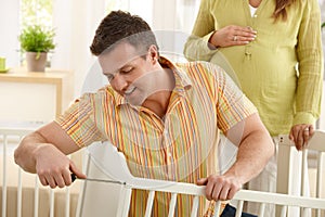 Dad fixing baby's bed