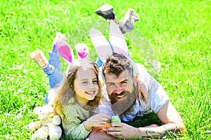 Dad and girl found easter eggs in traditional hunting game in. Man with beard and cute child lay on grass with easter