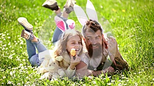 Dad and girl found easter eggs in traditional hunting game in. Man with beard and cute child lay on grass with easter