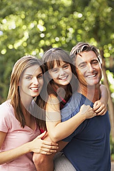 Dad Giving Daughter Piggyback On Family Walk