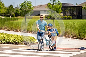 dad guiding his son first bike ride. dad and son enjoying fun bike outing. dad and son on biking adventure. dad and son