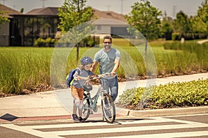 dad guiding his son first bike ride. dad and son enjoying fun bike outing. dad and son on biking adventure. dad and son